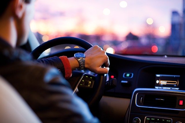 muž sedí v automobilu a řídí